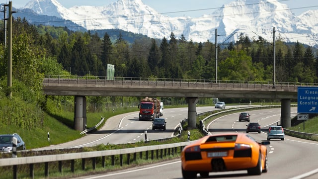 Autos fahren auf der Autobahn A1 unter einer Eisenbahnbrücke durch. Autos fahren auf der Autobahn A1 unter einer Eisenbahnbrücke durch.
