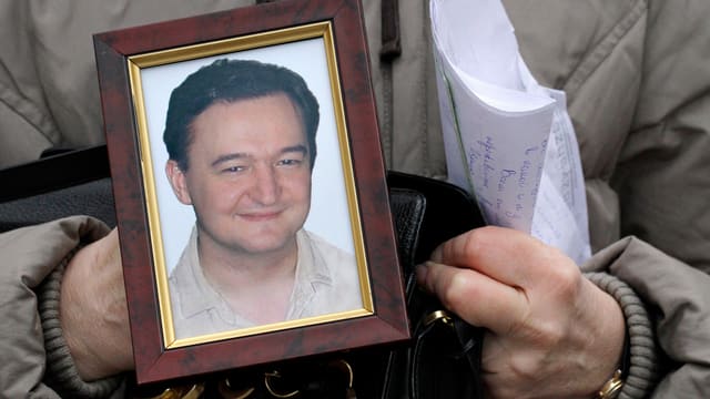 Foto von Magnitski in den Händen einer Frau. Foto von Magnitski in den Händen einer Frau.