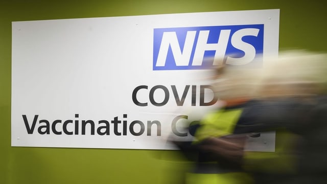 Plakat mit Wegweiser zu einem Impfzentrum des NHS Plakat mit Wegweiser zu einem Impfzentrum des NHS