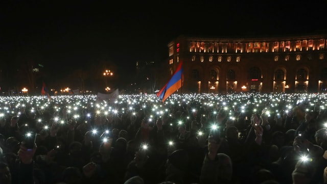Tausende Lichter von Smartphones, mittendrin eine Fahne. Tausende Lichter von Smartphones, mittendrin eine Fahne.