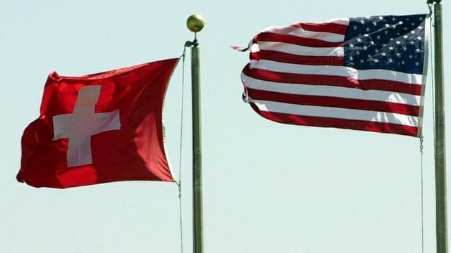 Eine Schweizer Fahne neben einer Fahne der USA Eine Schweizer Fahne neben einer Fahne der USA