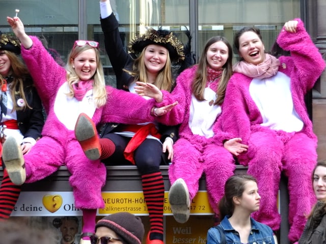 Winkende Mädchen in rosa Stramplern