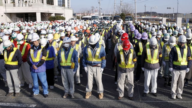 Lavurers a Fukushima che lavuran per la decontaminaziun dal terren fan ina minuta da silenzi Lavurers a Fukushima che lavuran per la decontaminaziun dal terren fan ina minuta da silenzi