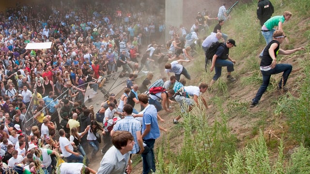 Menschenmasse, umkippender Zaun, fliehende Menschen Menschenmasse, umkippender Zaun, fliehende Menschen