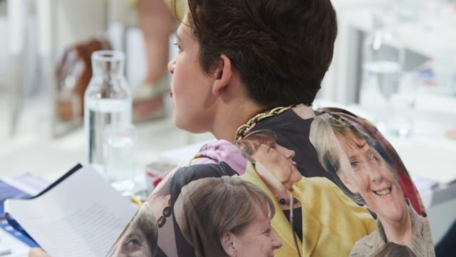 Eine Frau trägt eine Bluse, die mit Angela Merkel bedruckt ist. Eine Frau trägt eine Bluse, die mit Angela Merkel bedruckt ist.