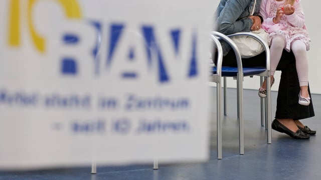 Frau mit Kind auf einem Arbeitslosenamt Frau mit Kind auf einem Arbeitslosenamt