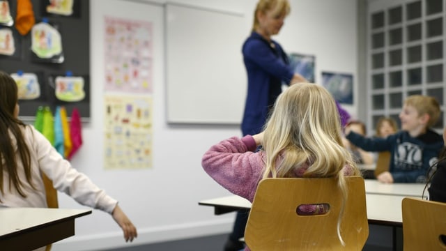 Symbolbild: Kinder und Lehrerin in einem Schulzimmer. Symbolbild: Kinder und Lehrerin in einem Schulzimmer.