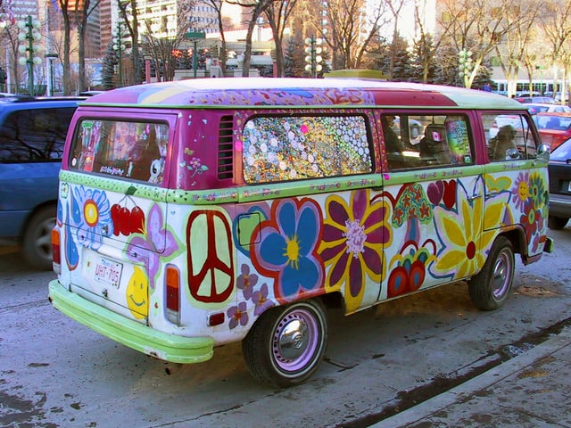 Ein alter VW-Bus komplett mit Blumen und einem Peace-Zeichen bemahlt.