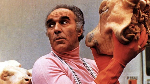 Ein Mann mit einem Schweinskopf in der Hand. Ein Mann mit einem Schweinskopf in der Hand.