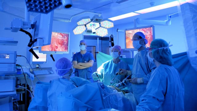 Ein Operationsteam des Kantonsspitals Aarau operiert in blauem Licht. Ein Operationsteam des Kantonsspitals Aarau operiert in blauem Licht.