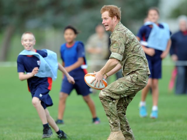 Prinz Harry spielt mit einem Rugby-Ball. Prinz Harry spielt mit einem Rugby-Ball.