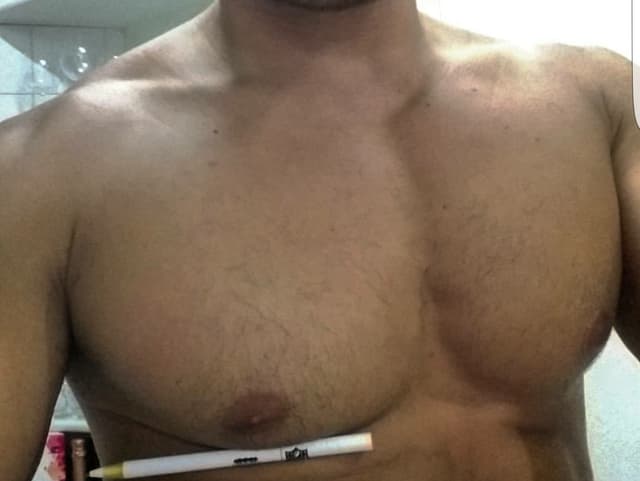 Mann mit Stift unter Brustmuskel