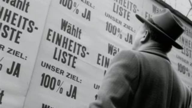 Mann steht vor Plakatwand mit nur einer Wahlliste. Mann steht vor Plakatwand mit nur einer Wahlliste.