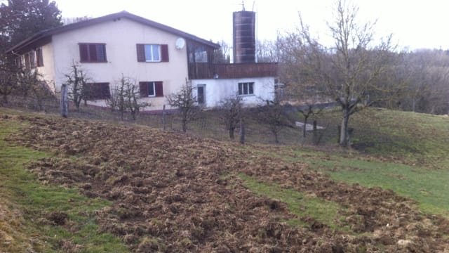 Umgepflügtes Feld, Haus im Hintergrund. Umgepflügtes Feld, Haus im Hintergrund.