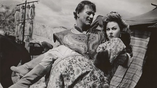 John Wayne trägt Susan Hayward auf Händen. John Wayne trägt Susan Hayward auf Händen.