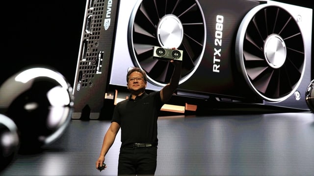 Der Nvidia-Chef, schwarze Hose, schwarzes T-Shirt, auf einer Bühne, hintendran die Projektion der neuen Grafik-Karte RTX 2080 - mit zwei riesigen Lüftern. Der Nvidia-Chef, schwarze Hose, schwarzes T-Shirt, auf einer Bühne, hintendran die Projektion der neuen Grafik-Karte RTX 2080 - mit zwei riesigen Lüftern.
