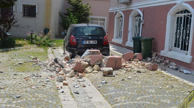 Steinstücke liegen in einem Innenhof vor einem Auto. Steinstücke liegen in einem Innenhof vor einem Auto.