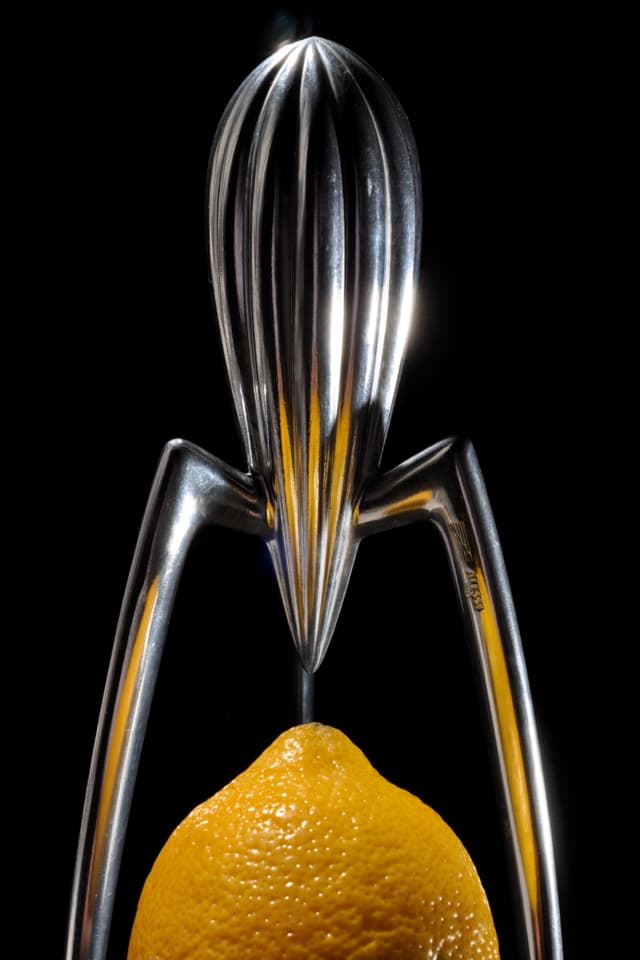Zitronenpresse aus Metall mit langen spinnenartigen Beinen. 