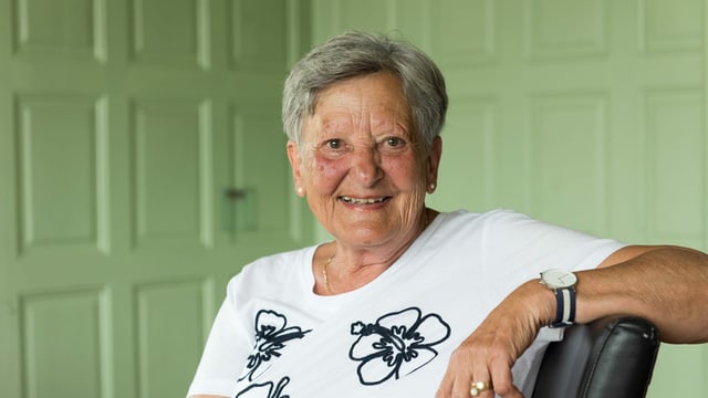 eine ältere Frau lächelt freundlich in die Kamera eine ältere Frau lächelt freundlich in die Kamera
