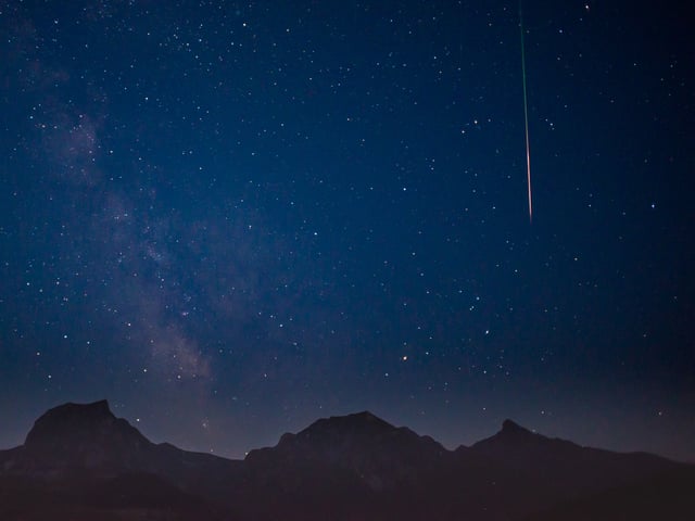 Nacht mit Sternenhimmel. Rechts ein heller Strich, die Sternschnuppe.