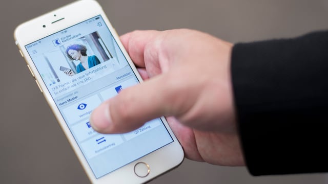Eine Hand hält ein Smartphone und bedient eine App der ZKB Eine Hand hält ein Smartphone und bedient eine App der ZKB