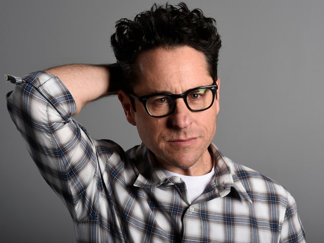 J.J. Abrams trägt ein Karo-Hemd und greift sich an den Hinterkopf. J.J. Abrams trägt ein Karo-Hemd und greift sich an den Hinterkopf.