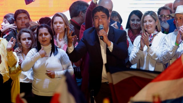 Carlos Alvarado redet in ein Mikrofon. Carlos Alvarado redet in ein Mikrofon.