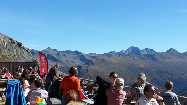 Zahlreiche Leute auf der sonnenübrfluteten Terrasse auf dem Strelapass Zahlreiche Leute auf der sonnenübrfluteten Terrasse auf dem Strelapass