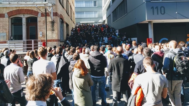 Menschen vor Gebäude Menschen vor Gebäude