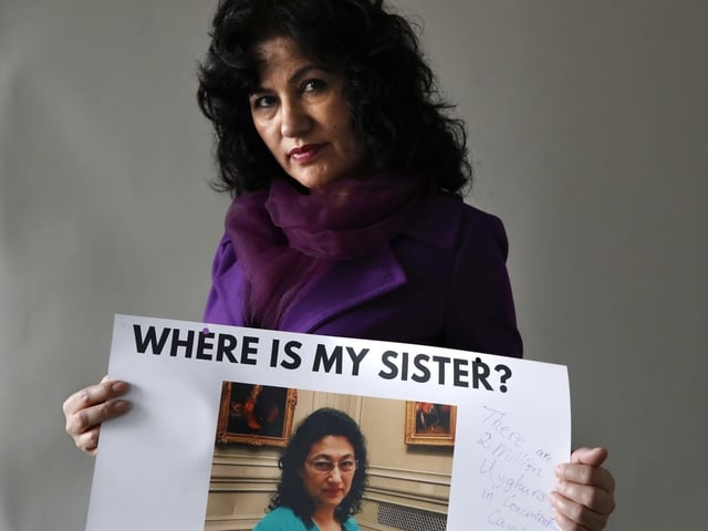 Uigurische Exilantin mit Bild ihrer Schwester, die möglicherweise in einem Internierungslager verschwunden ist. Uigurische Exilantin mit Bild ihrer Schwester, die möglicherweise in einem Internierungslager verschwunden ist.