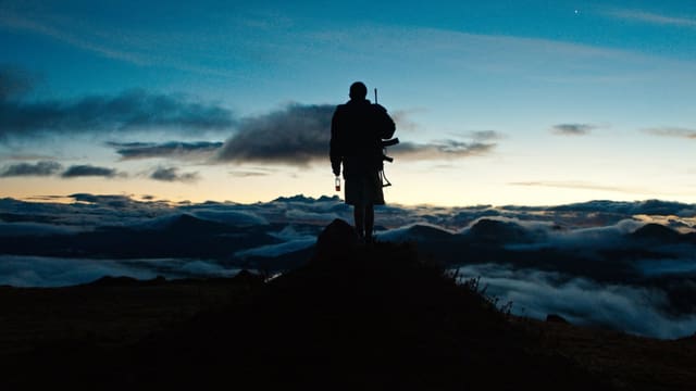 Ein Junge steht oben auf einem Berg. Ein Junge steht oben auf einem Berg.