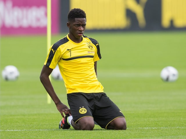 Ousmane Dembélé kniet auf dem Rasen.