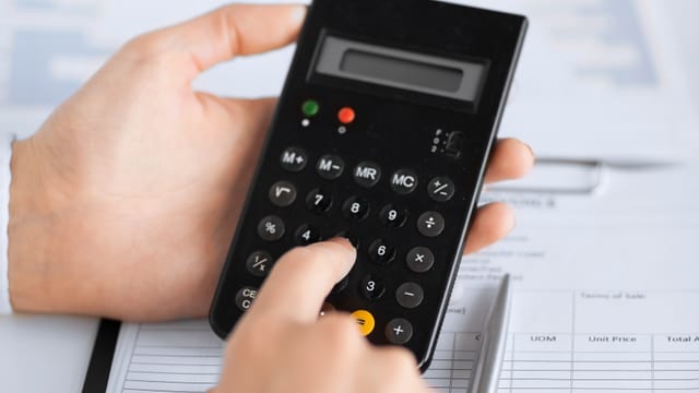 Hände halten eine Taschenrechner Hände halten eine Taschenrechner