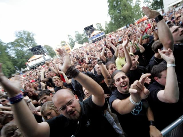 Begeisterte Metal-Fans jubeln einer Band zu Begeisterte Metal-Fans jubeln einer Band zu
