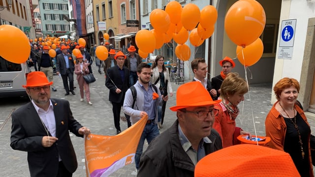 Menschen in den CVP-Farben ziehen durch Baden. Menschen in den CVP-Farben ziehen durch Baden.