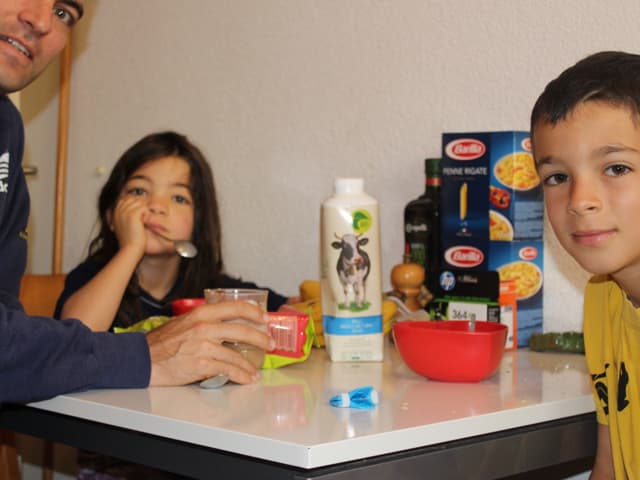 Mann mit zwei Kindern am Frühstückstisch.