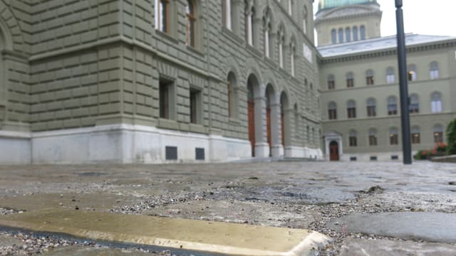Im Vordergrund eine goldene Messingplatte, hinten die Bundeshauskuppel. Im Vordergrund eine goldene Messingplatte, hinten die Bundeshauskuppel.