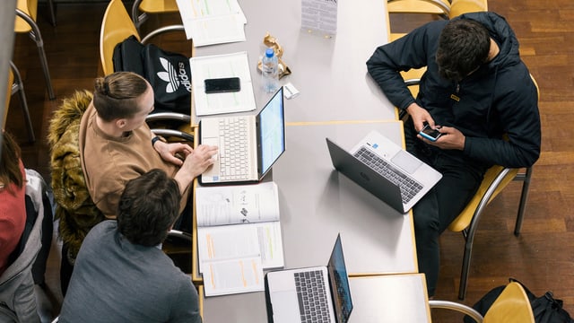 Studenten am Schreibtisch vor dem Laptop und dem Handy. Studenten am Schreibtisch vor dem Laptop und dem Handy.