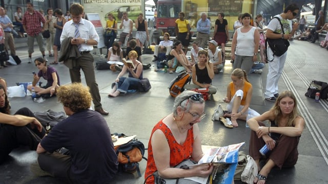Wartende Menschen sitzen auf dem Boden Wartende Menschen sitzen auf dem Boden