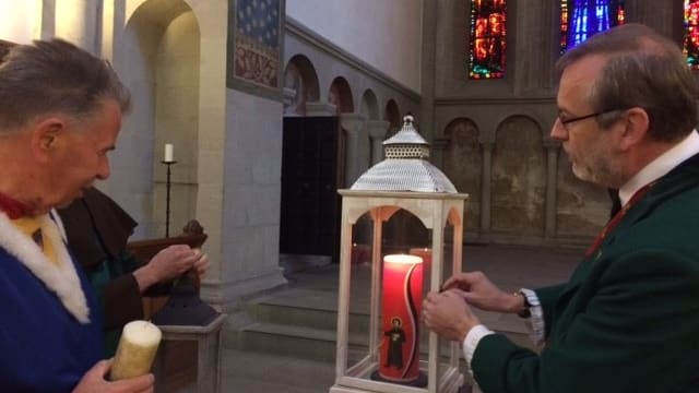 Mehrere Männer stehen um Kerze Mehrere Männer stehen um Kerze