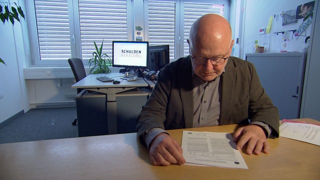 Mann in einem Büro studiert ein Dokument. Mann in einem Büro studiert ein Dokument.