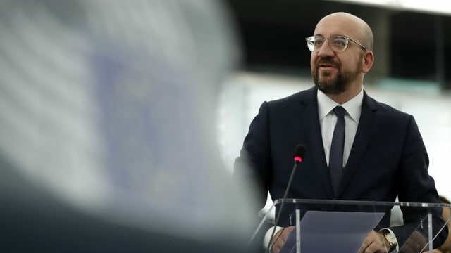 Purtret da Charles Michel: In um grond cun in chau blut ed egliers cun ina rama transparenta, barba en fatscha. El porta in vestgì. Purtret da Charles Michel: In um grond cun in chau blut ed egliers cun ina rama transparenta, barba en fatscha. El porta in vestgì.