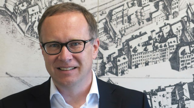 Ein Mann mit Brille vor einem alten Bild der Stadt Luzern. Ein Mann mit Brille vor einem alten Bild der Stadt Luzern.