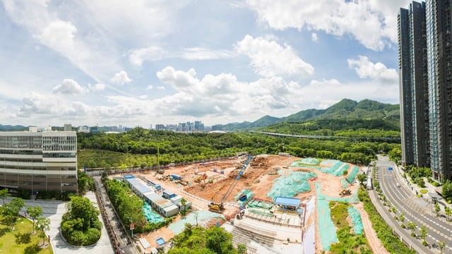eine Baustelle umringt von Hochhäusern und Wald eine Baustelle umringt von Hochhäusern und Wald