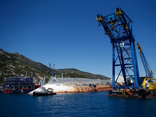 Das havarierte Kreuzfahrtschiff «Costa Concordia» liegt vor der italienischen Insel Giglio im Mittelmeer – umkreist von Kränen. (reuters)
