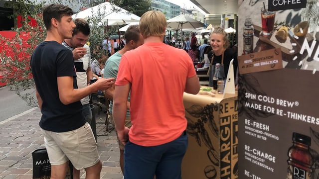 Junge Männer probieren das kalte Getränk an einem Stand. Junge Männer probieren das kalte Getränk an einem Stand.