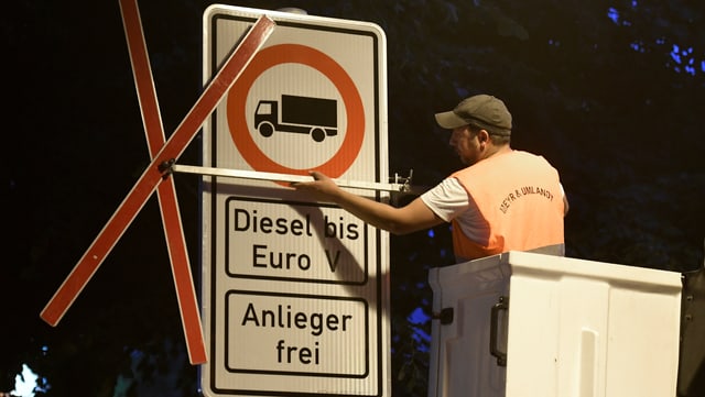 Ein Arbeiter befestigt die neuen Dieselverbotsschilder