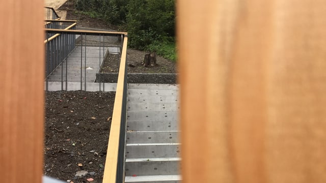 Betontreppe mit hellem Holzgeländer, Nahaufnahme. Betontreppe mit hellem Holzgeländer, Nahaufnahme.