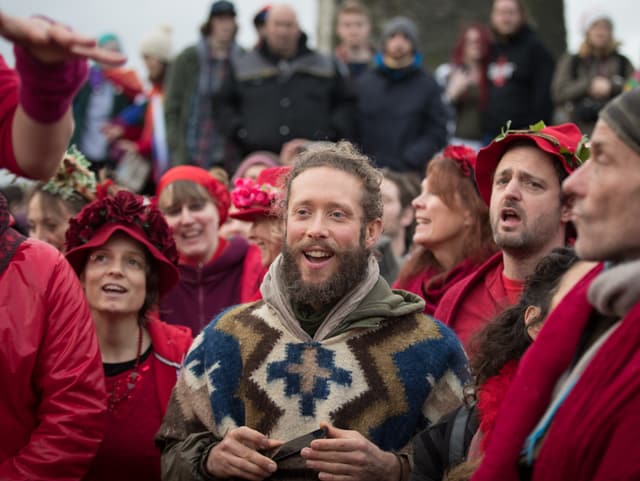 Eine Gruppe von Leuten in roten Kleidern singt Eine Gruppe von Leuten in roten Kleidern singt
