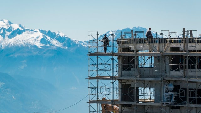 Ein Rohbau in Crans-Montana (Wallis). Im Hintergrund schneebedeckte Berge. Ein Rohbau in Crans-Montana (Wallis). Im Hintergrund schneebedeckte Berge.